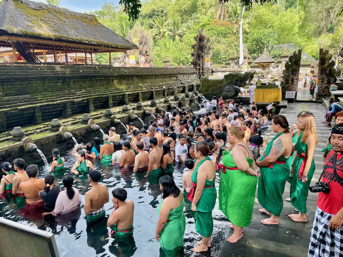 Pilgrims and Tourists immersing themselves in the holy water at Tirta Empul Temple Ubud Bali