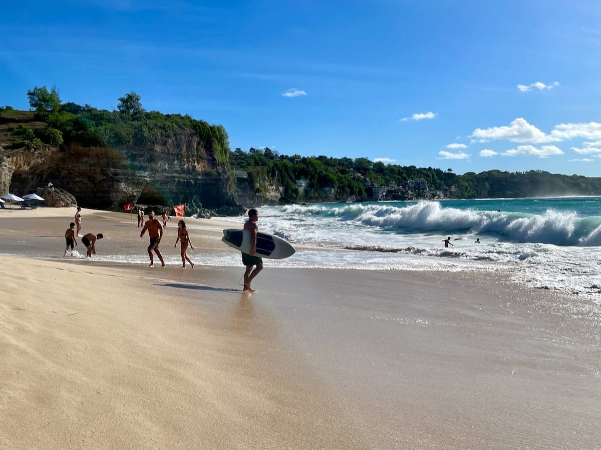 Surfer entering water at Dreamland Beach Bali Indonesia